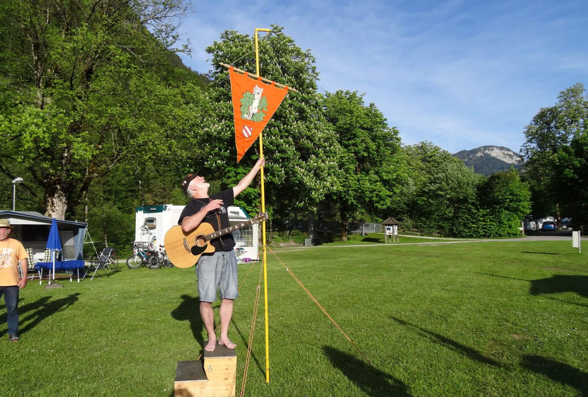 Jürgen mit Gitarre vor Vereinsfahne